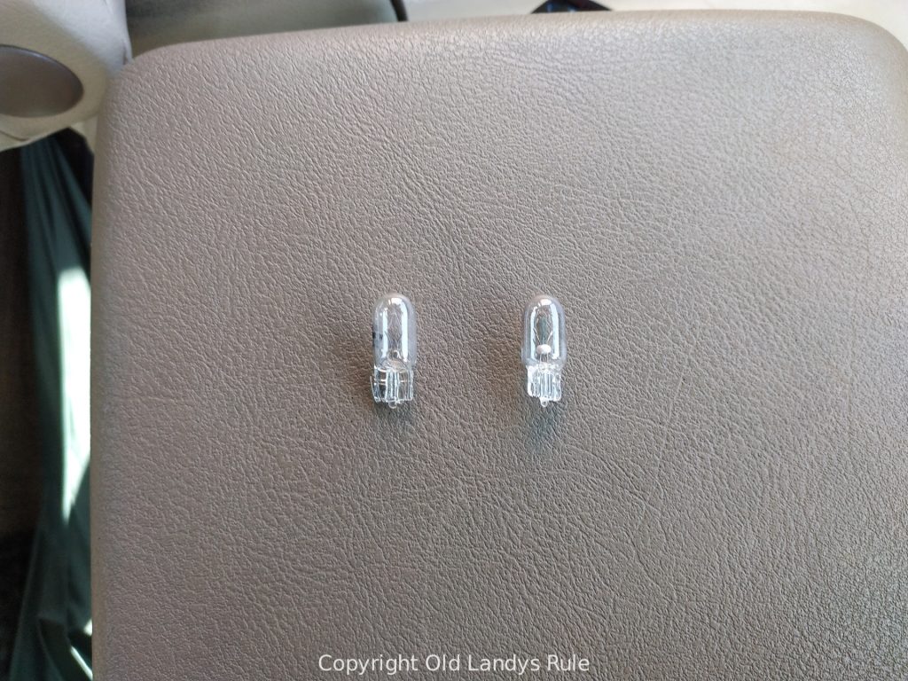 Two 12v capless bulbs sat side by side on a vinyl background