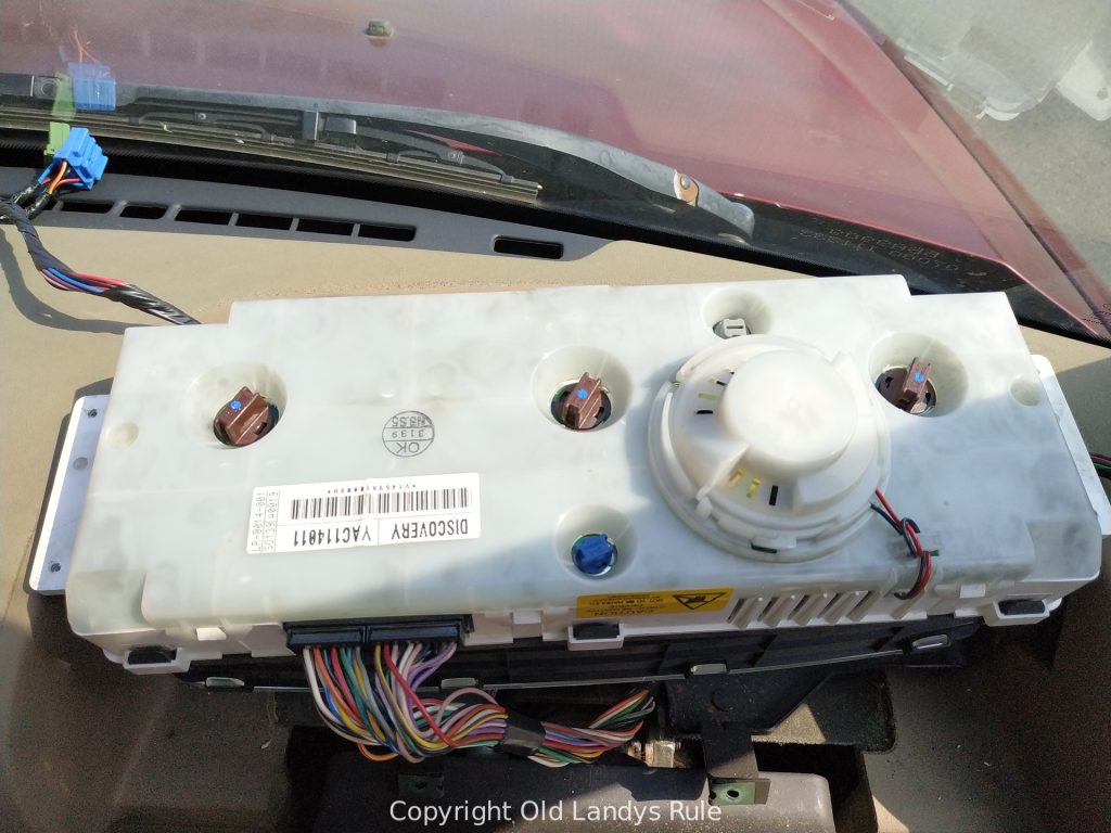 Looking down at the rear of a Discovery 2 Dashboard Clock Cluster with wires coming out.