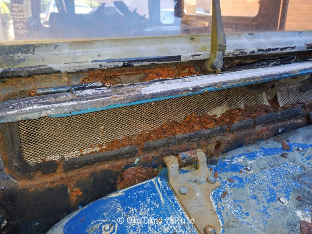 Close up of a Land Rover Series 3's bulkhead vent, and the mountains of rust plaguing it.