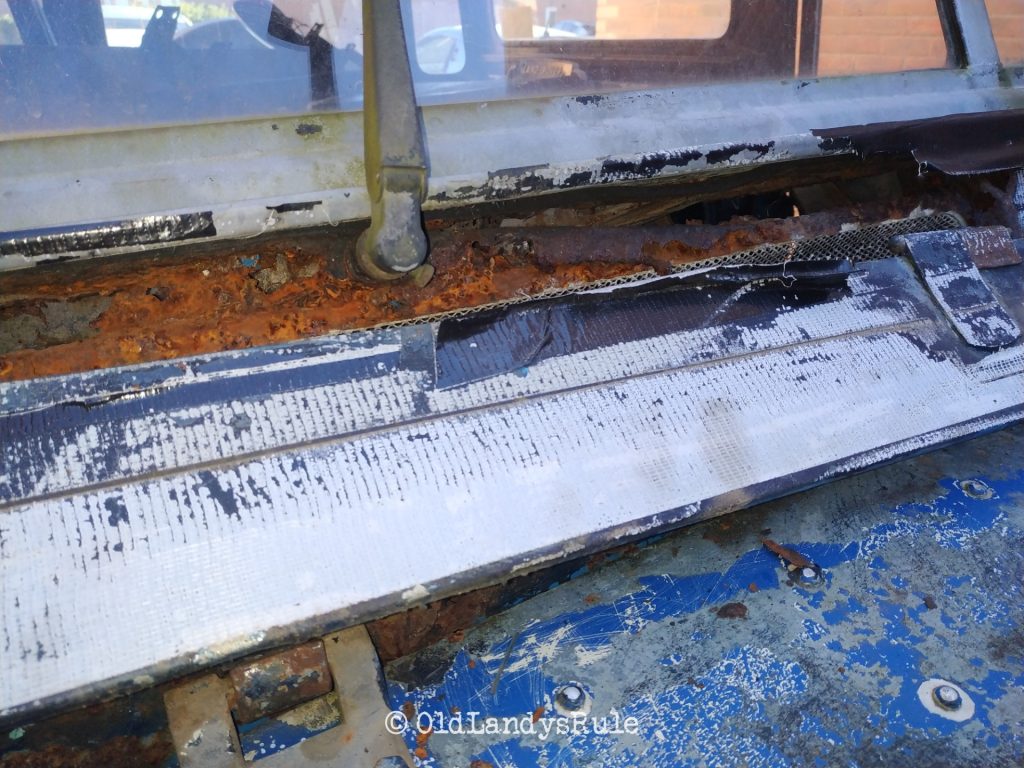 Close up of a Land Rover Series 3's bulkhead vent, and the mountains of rust plaguing it.