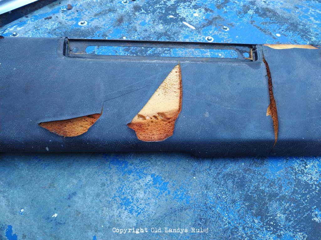 Land Rover Series 3 dashboard top, showing the sun damage and cracked black vinyl, with some foam underneath peeking through