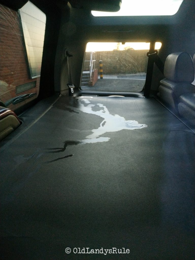 Rear parcel shelf of a Land Rover Discovery 2, with a fairly large puddle on it.