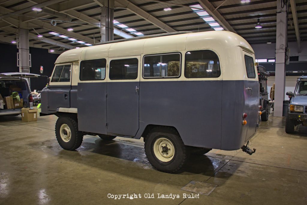 A blue and cream Land Rover Series 2a Forward Control, viewed from the rear left side. The top half is cream and the lower half is blue.